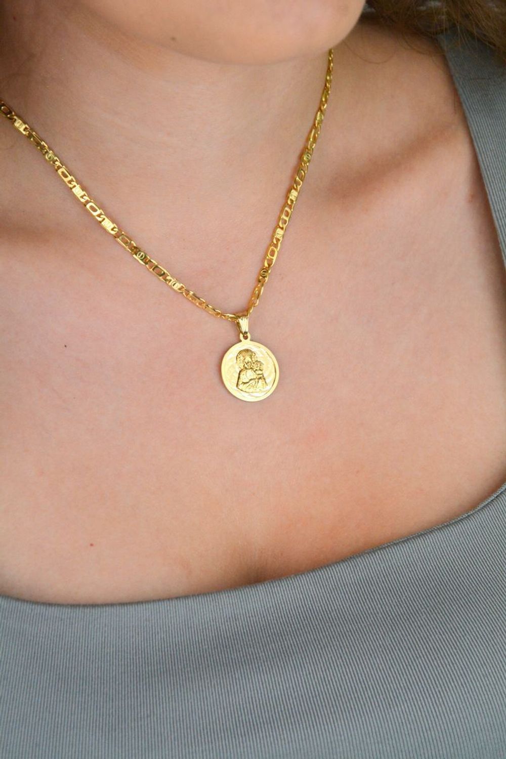 Złota zawieszka próby 585 z wizerunkiem Matki Boskiej z Dzieciątkiem. Wymiary 2 cm, waga 2,63 g. Klasyczny medalik religijny w eleganckiej formie.1.jpg